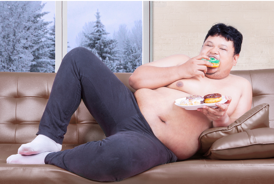 Толстый ест. Жирный человек на диване. Толстый человек ест сладкое.
